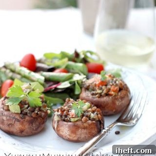 Close-up shot of a baked mini Portobello mushroom, generously stuffed with a hearty blend of lentils and vegetables, topped with melted cheese, ready to be enjoyed.