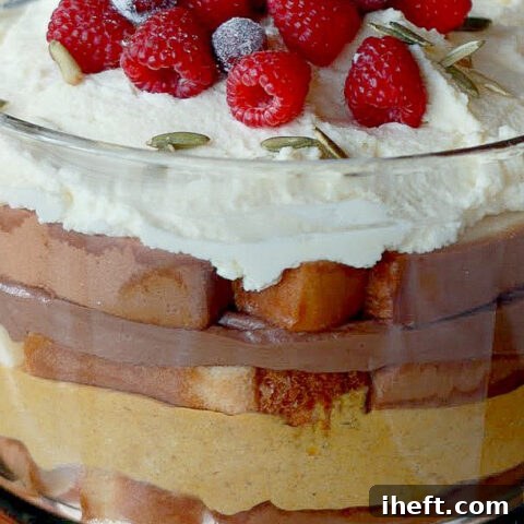 A close-up look at a Thanksgiving trifle made with distinct layers of chocolate mousse and pumpkin mousse, adorned with whipped cream, showcasing its inviting textures and vibrant autumn colors.