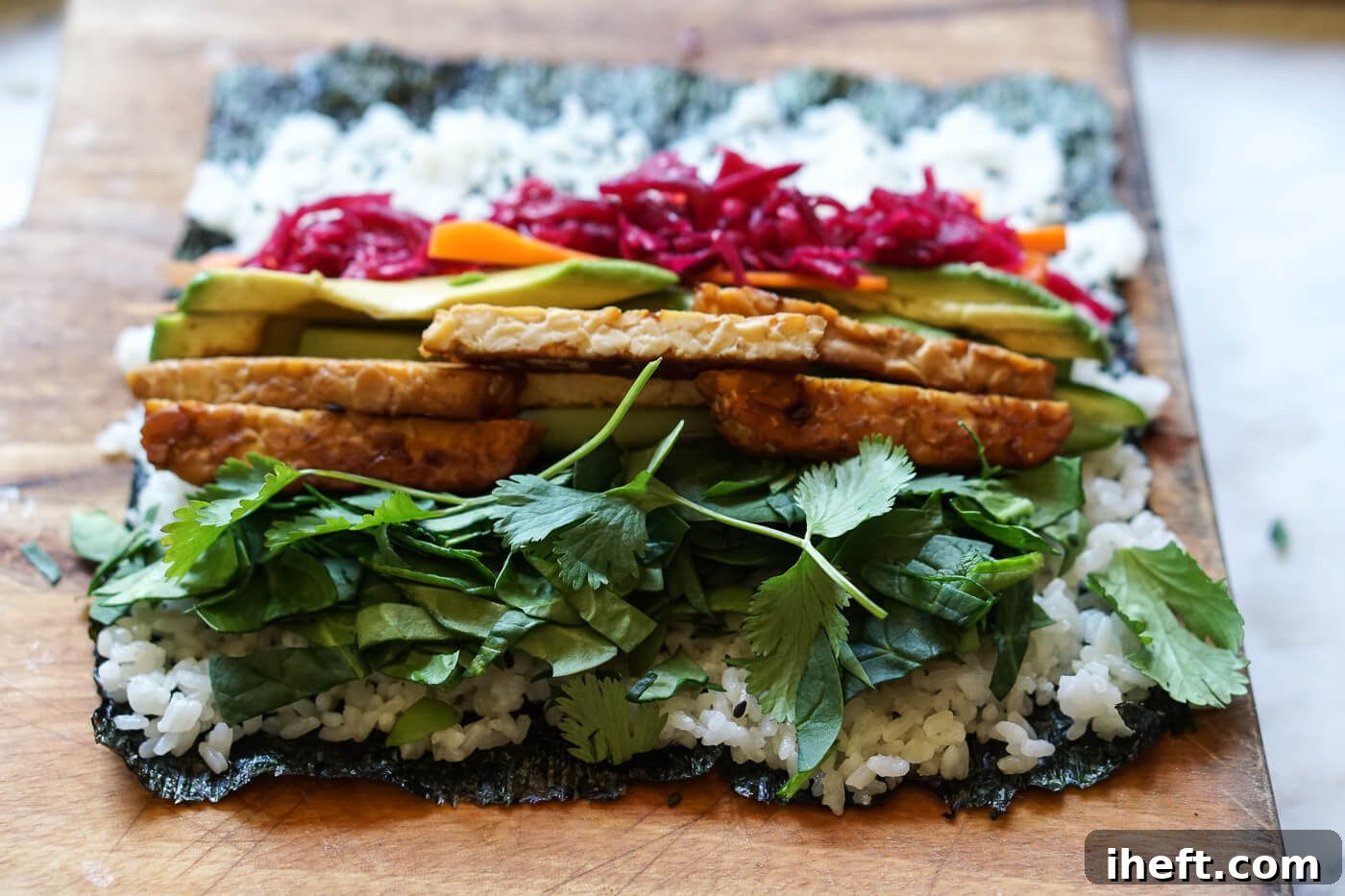 Sushi burrito fillings are placed on top of nori and rice.