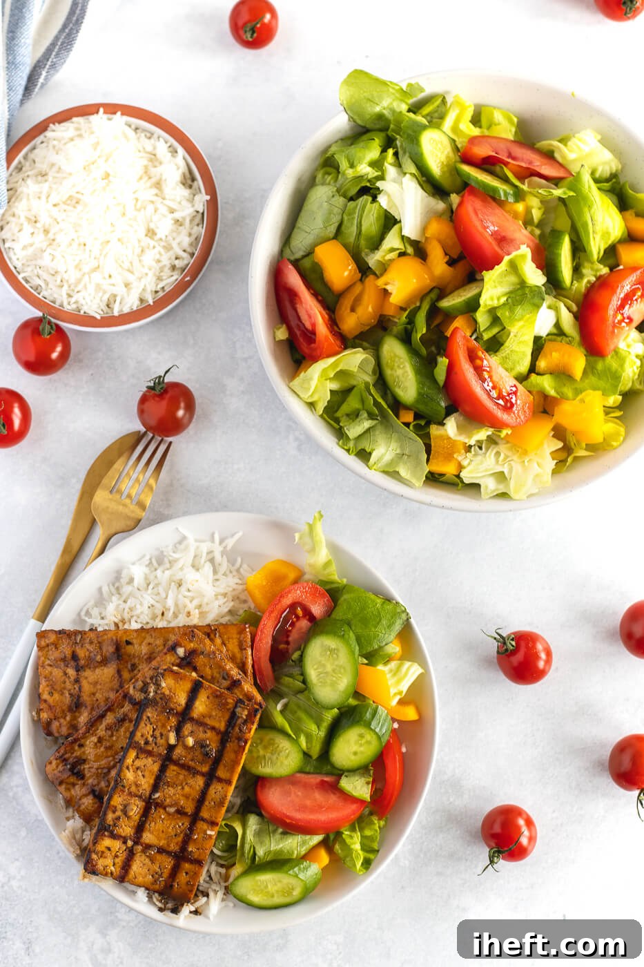 An overhead photo of grilled tofu on top of rice and vegetables. A salad is on the side. This is a great vegetarian BBQ recipe. 