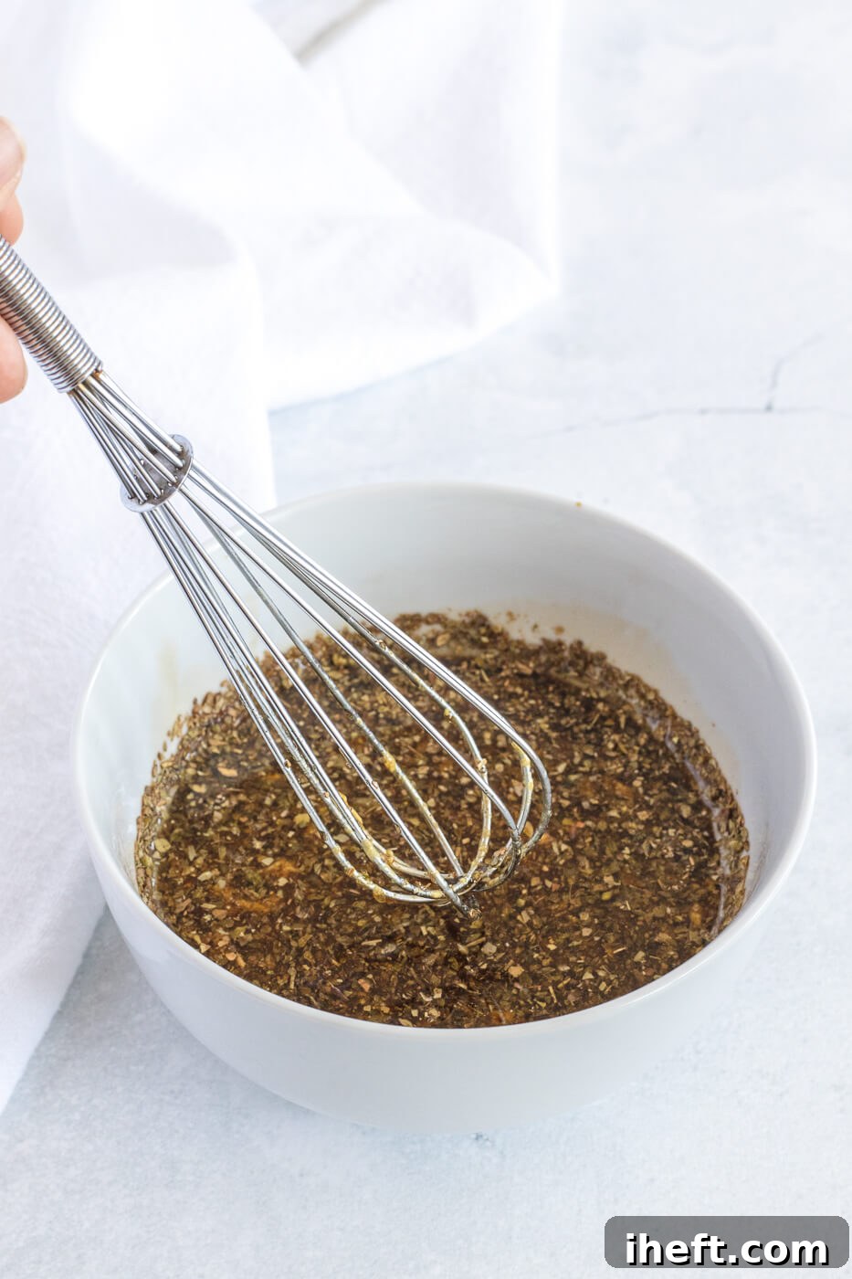 Mediterranean marinade is whisked together in a white bowl.