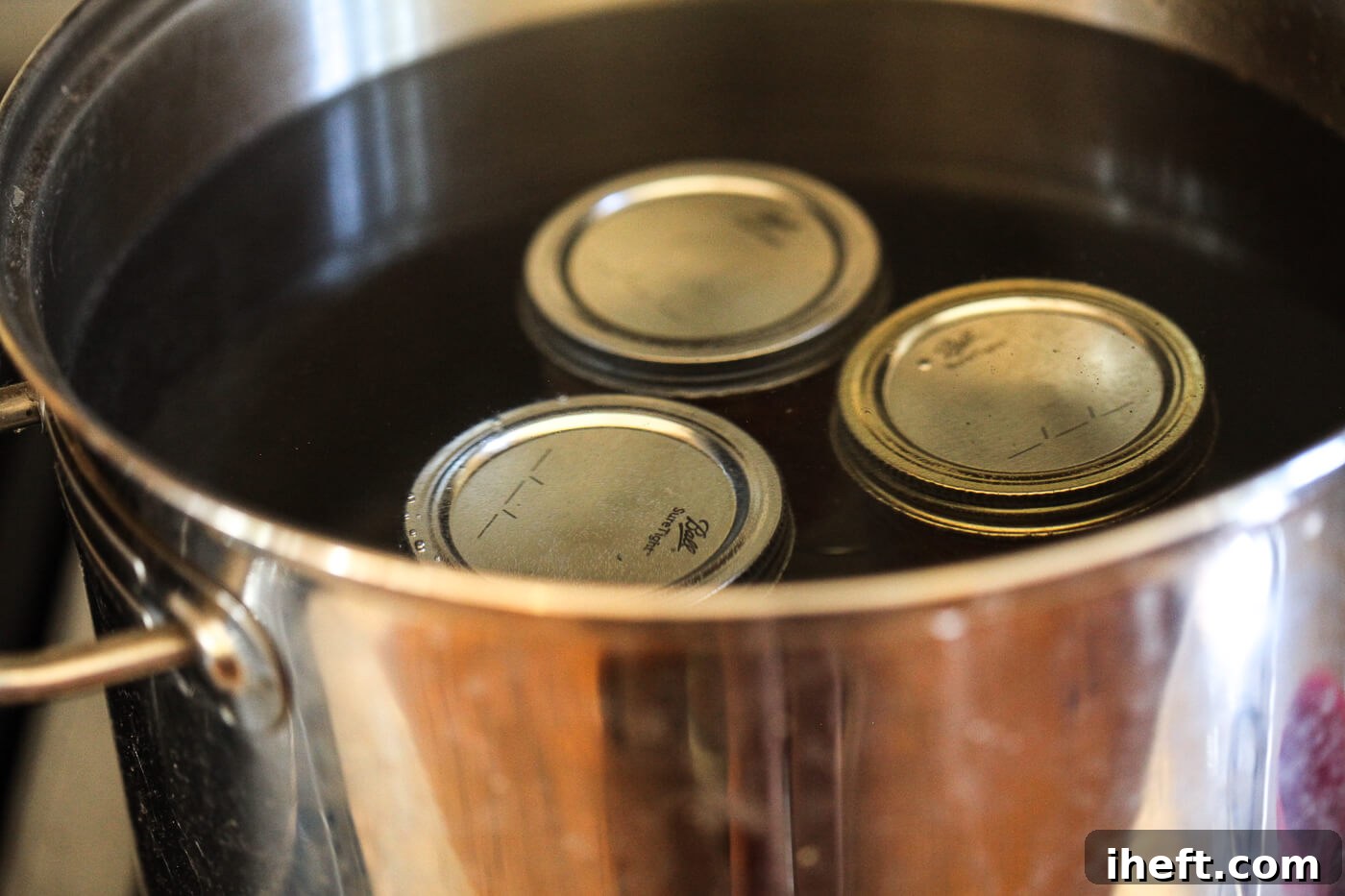 Ball canning jars in a large pot of water.