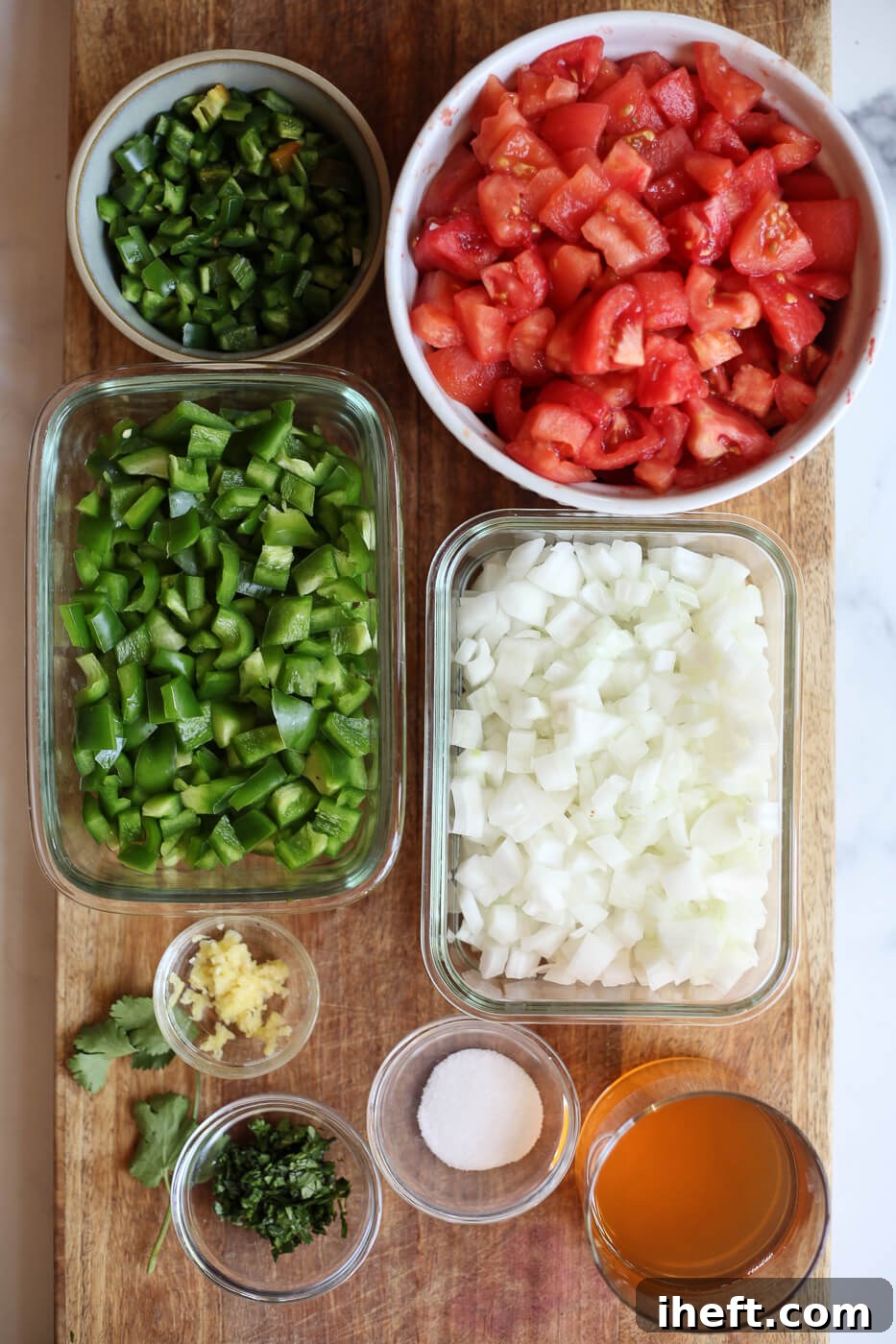 The ingredients for homemade canned salsa are prepared on a cutting board and include tomatoes, bell pepper, onion, jalapeno, garlic, cilantro, salt, and apple cider vinegar. 