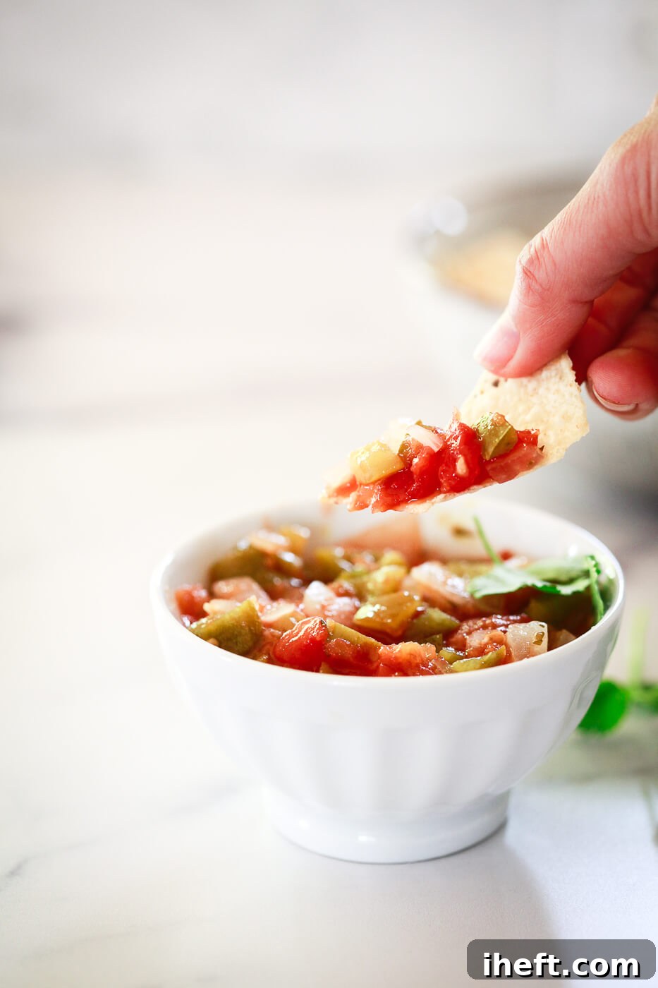 A chip scoops up homemade salsa. 