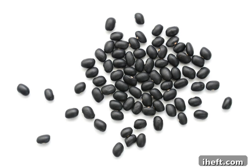 Close up photo of dried black beans, showing their rich dark color.