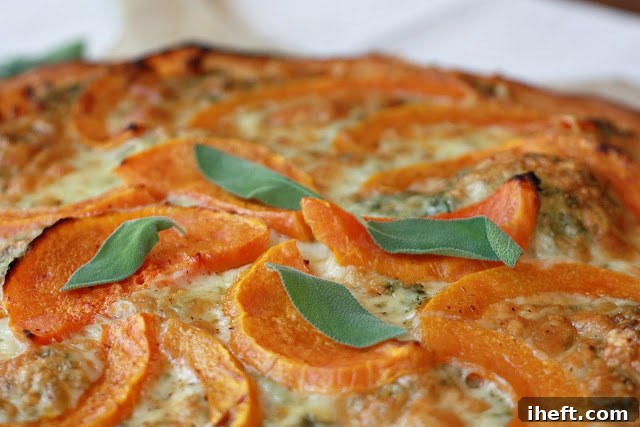 A whole roasted butternut squash pizza, freshly out of the oven, with a golden-brown crust.