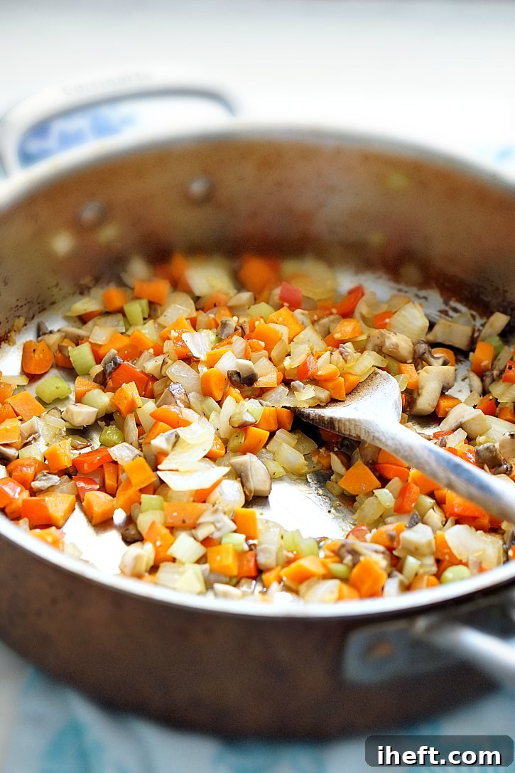 Mushrooms, carrots, celery, and onion being sautéed for a rich and flavorful vegan lentil meatloaf base.