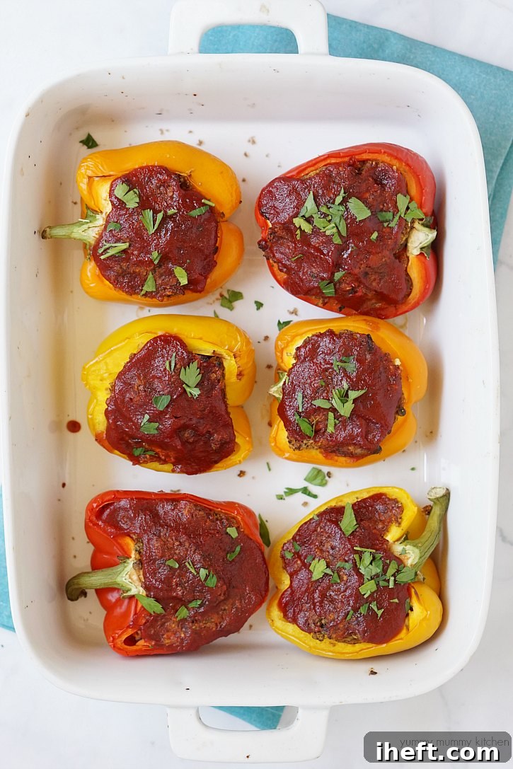 Colorful bell peppers generously stuffed with a savory vegan lentil meatloaf mixture, baked to perfection.