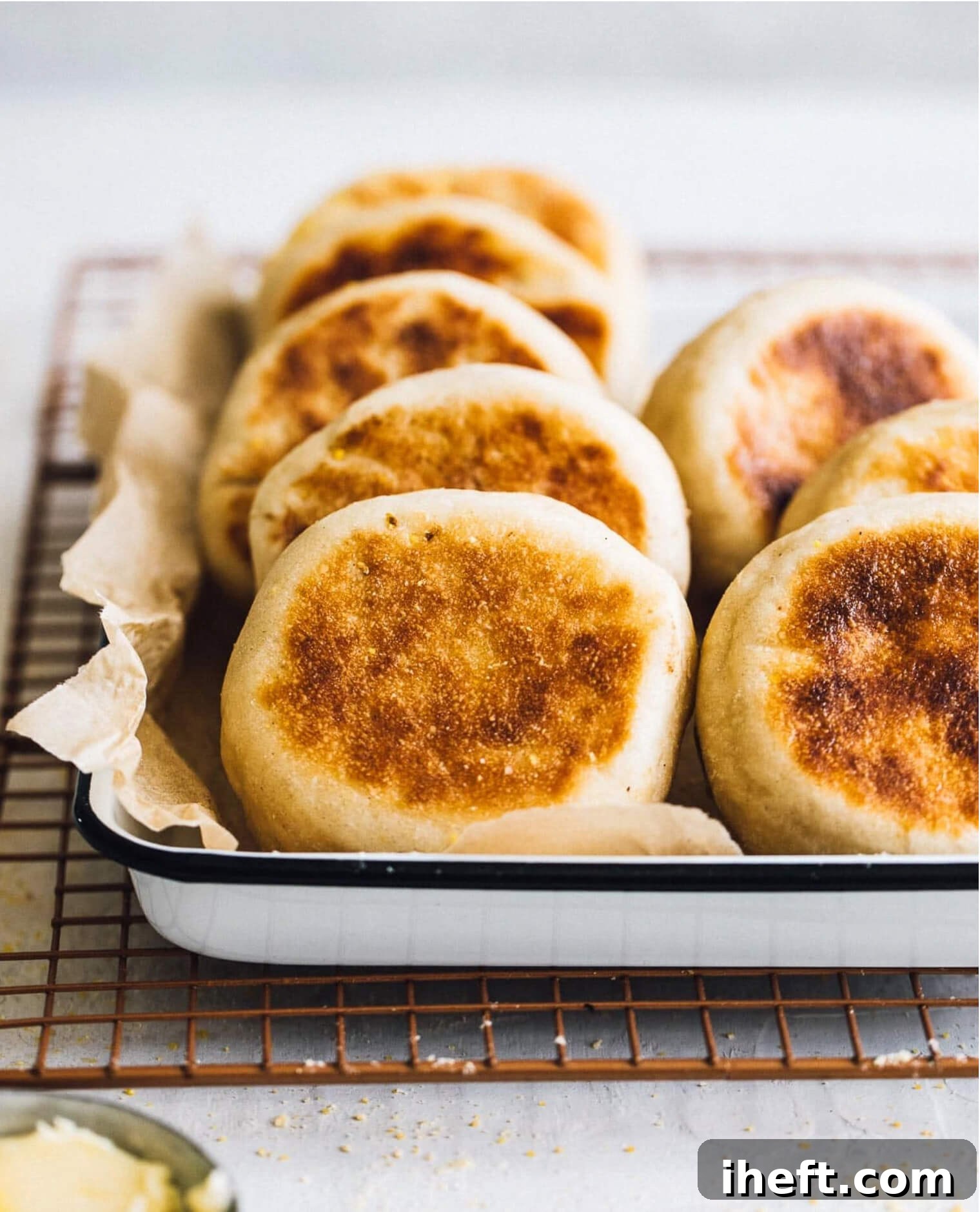 Golden brown Sourdough English Muffins, homemade and cooked to perfection on a griddle, showcasing their fluffy texture.