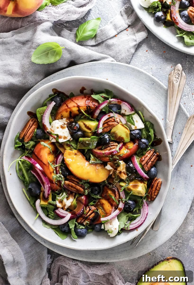 A stunning healthy salad featuring beautifully grilled peaches, red onion, and creamy avocado, perfect as a Blackstone griddle recipe.