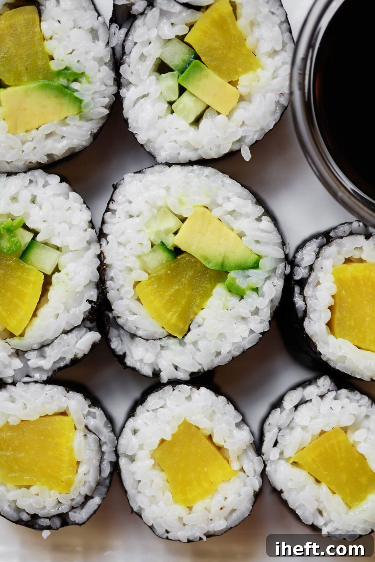 An overhead close-up photo of vibrant oshinko rolls with avocado and cucumber, showcasing a delicious veggie sushi recipe.