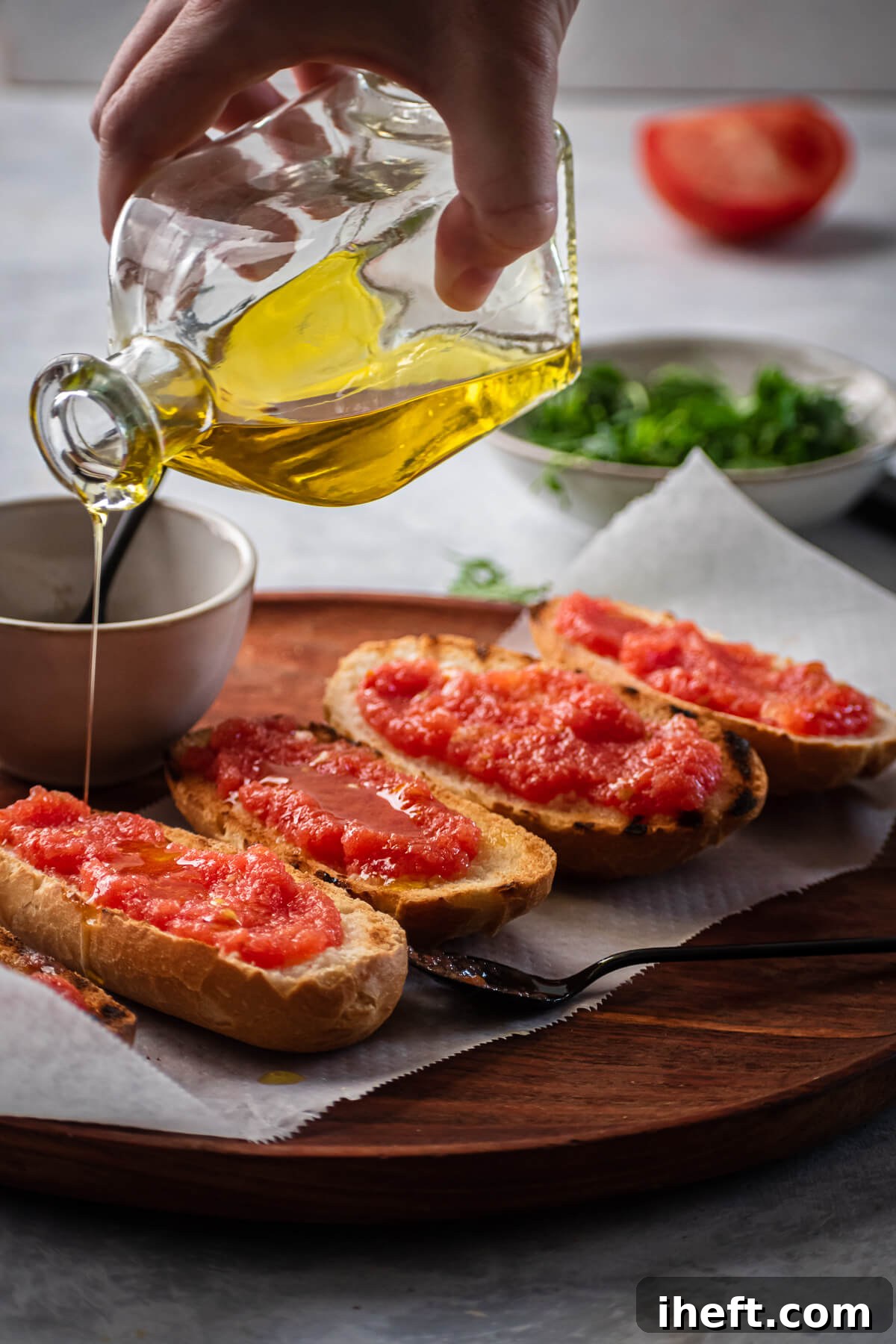 Olive oil is drizzled over freshly made pan con tomate recipe.