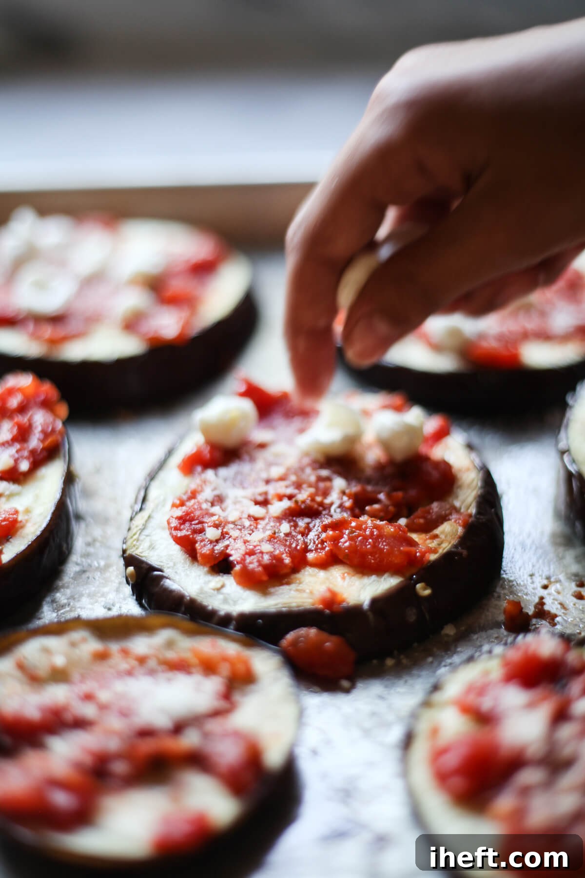 Baked eggplant rounds are topped with sauce and cheese to make mini eggplant pizzas. 