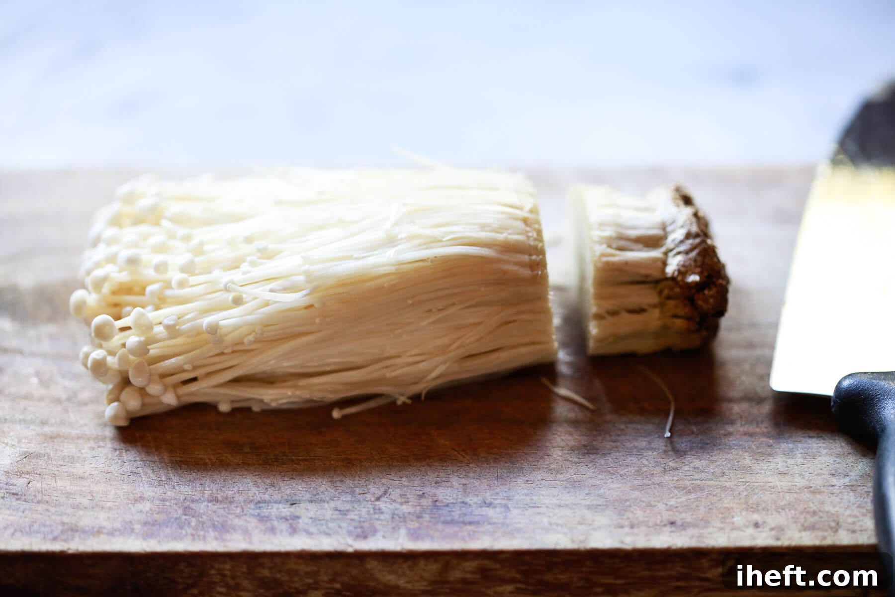 Enoki mushrooms with the root cut off.
