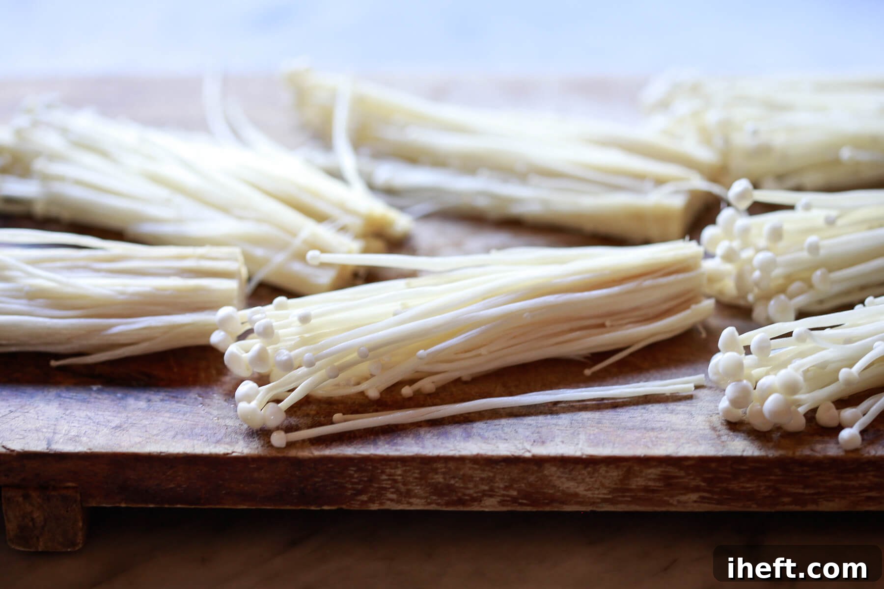 Enoki mushrooms divided into about 6 bundles.