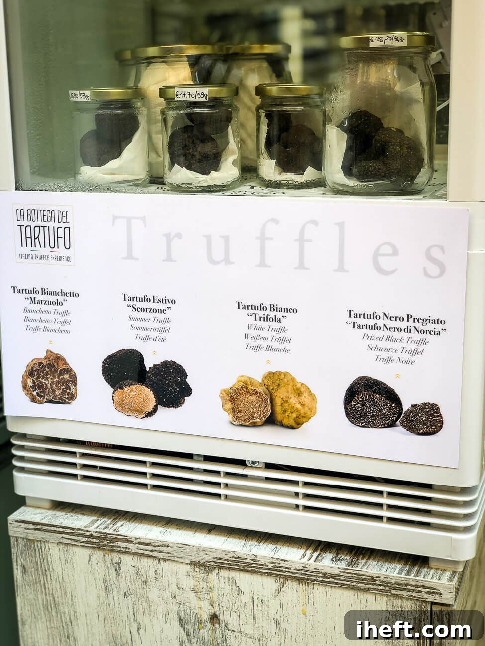 Jars of black truffles next to a sign showing four different types of Italian white and black truffles. This picture was taken in Florence Italy. 
