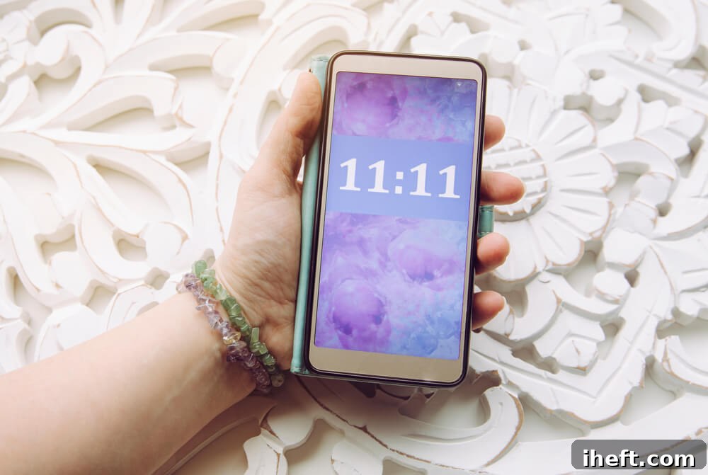 A hand holds a phone with 11:11 on the screen to show an angel number. 