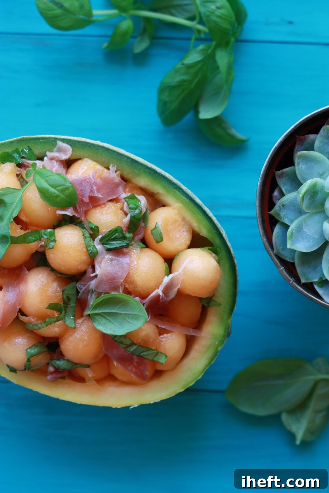 Beautifully plated melon and prosciutto salad, garnished with fresh basil leaves, showcasing its vibrant colors and inviting texture.