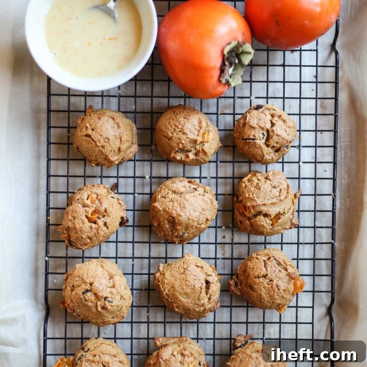 A generous stack of soft persimmon cookies, lightly glazed and dusted with orange zest, resting on a wire cooling rack, inviting a warm, comforting bite.