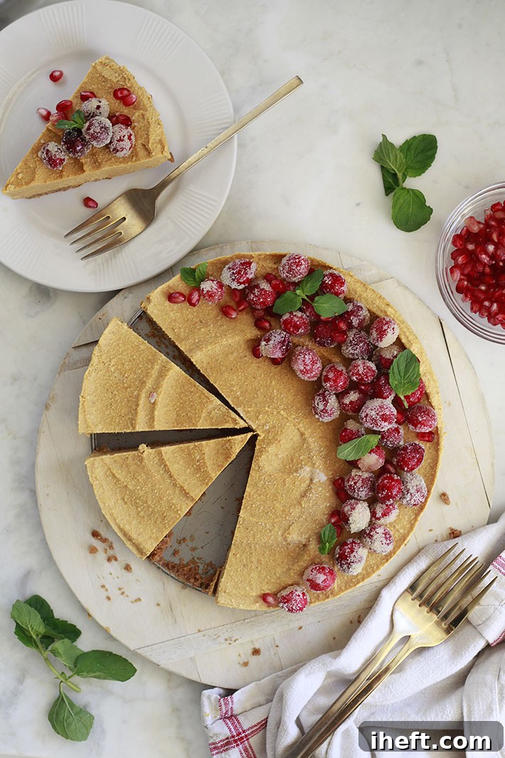 An overhead photo of a vegan pumpkin cheesecake topped with sugared cranberries. 