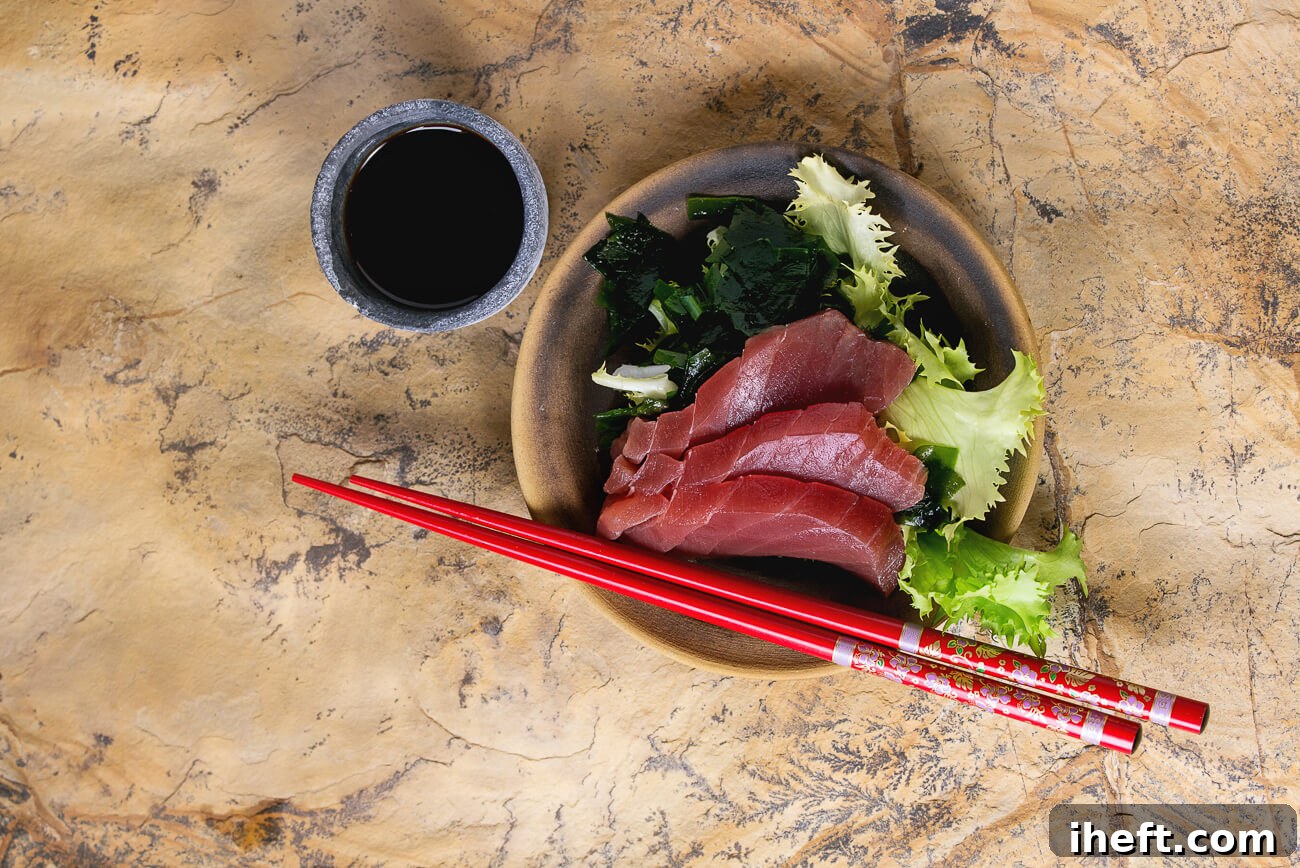 A vibrant bowl of fresh greens adorned with perfectly sliced ahi tuna sashimi, showcasing the pure, unadorned beauty of raw fish.
