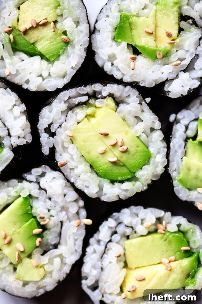 A close-up photograph of artfully crafted avocado sushi rolls, showcasing perfectly prepared sushi rice made effortlessly at home using an Instant Pot.