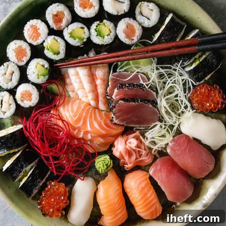 A beautiful platter with sushi rolls at top, nigiri at bottom, and sashimi in the middle.