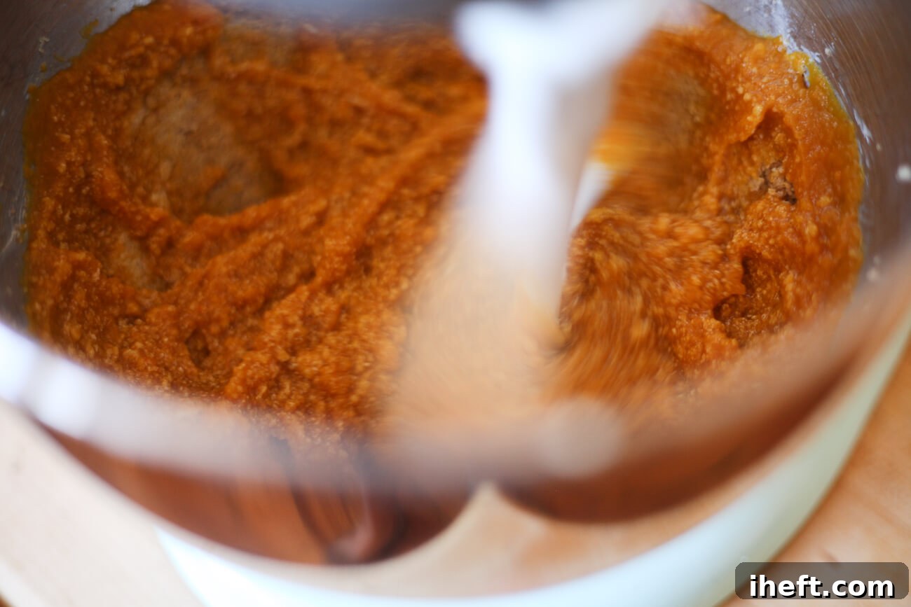 Wet ingredients for vegan pumpkin cookies are mixed together in a stand mixer with paddle attachment.