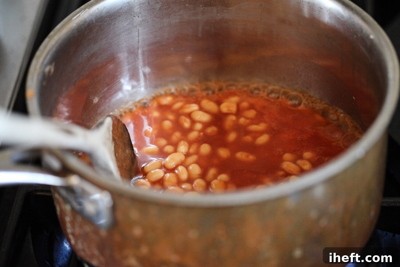 Heinz British beans simmer gently in a small saucepan on the stove.