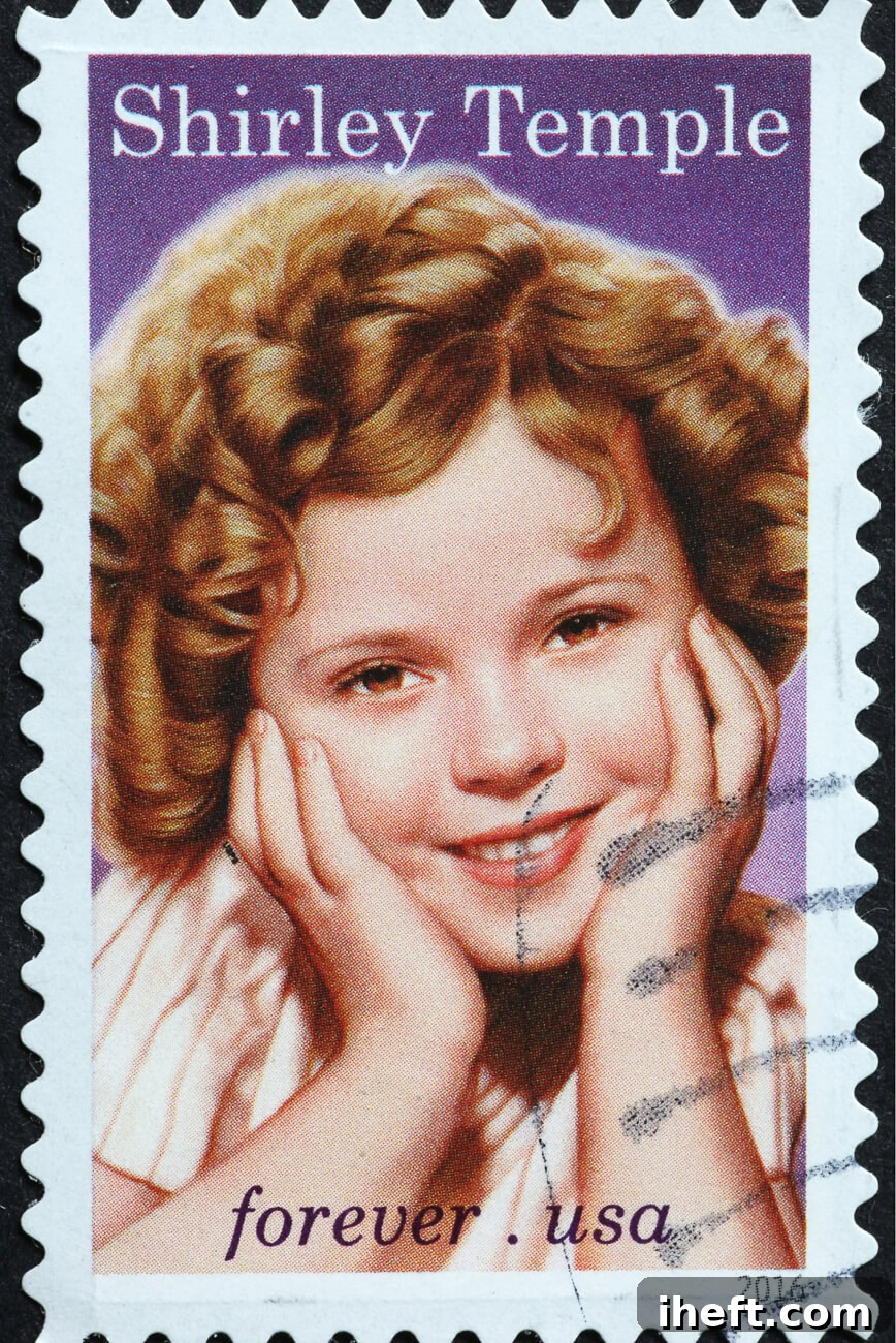 A vintage postage stamp featuring a picture of young Shirley Temple, the iconic child actress, smiling brightly.