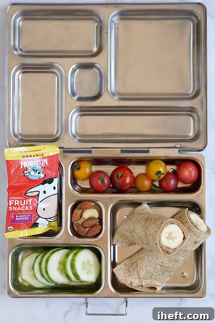 A vibrant vegetarian kids lunch box featuring a banana almond butter tortilla wrap, fresh fruit, crunchy veggies, wholesome nuts, and Horizon fruit snacks.