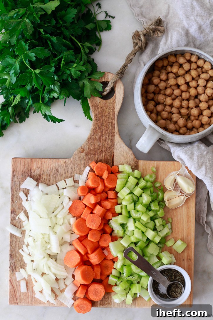 This delicious and easy vegetable soup begins with chopping fresh onions, carrots, celery, thyme, and preparing chickpeas. Simple prep for a wholesome meal.