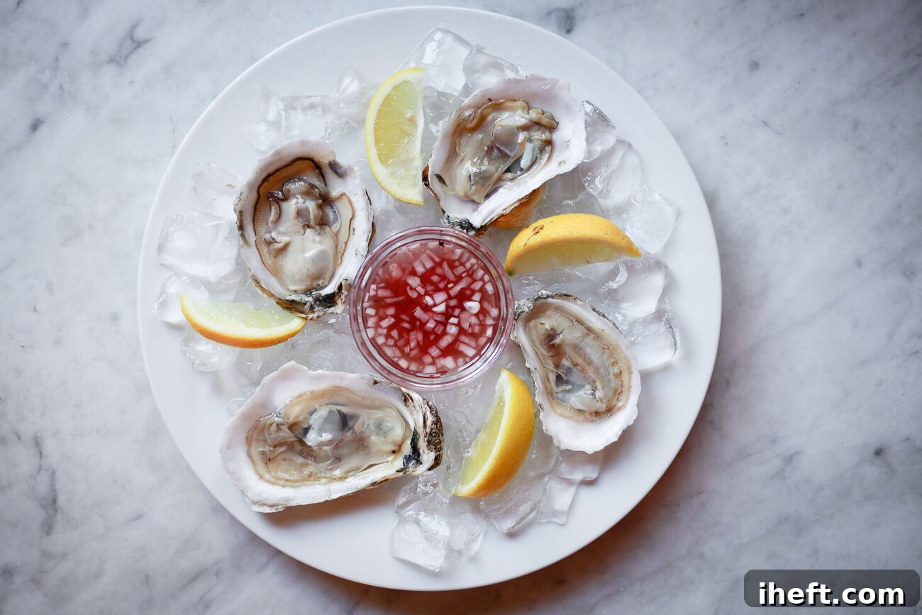 Four raw oysters on the half shell with a small bowl of mignonette sauce in the middle.