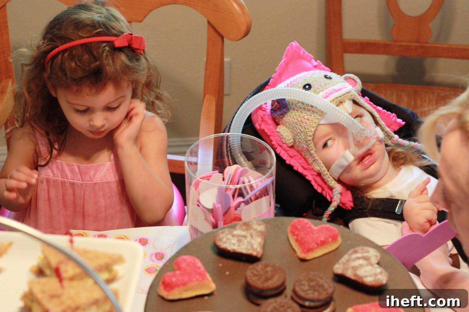 Two young girls, B and Gwendolyn, happily engaged in making Valentine's crafts with foam stickers.