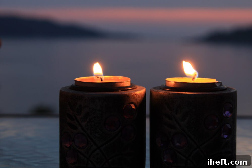 Two candles burn side by side in front of a sunset, symbolizing twin flame connection and romantic love.