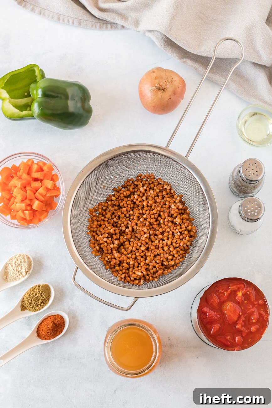 All the fresh ingredients for a flavorful lentil chili, neatly arranged on a pristine white countertop, including a green bell pepper, a yellow onion, salt and pepper, diced carrots, a selection of aromatic spices, rich vegetable broth, wholesome lentils, and vibrant diced tomatoes.