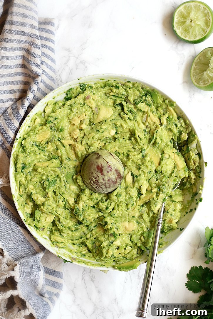 A large bowl of homemade guacamole with a pit in the middle, ready to be served with tortilla chips. 