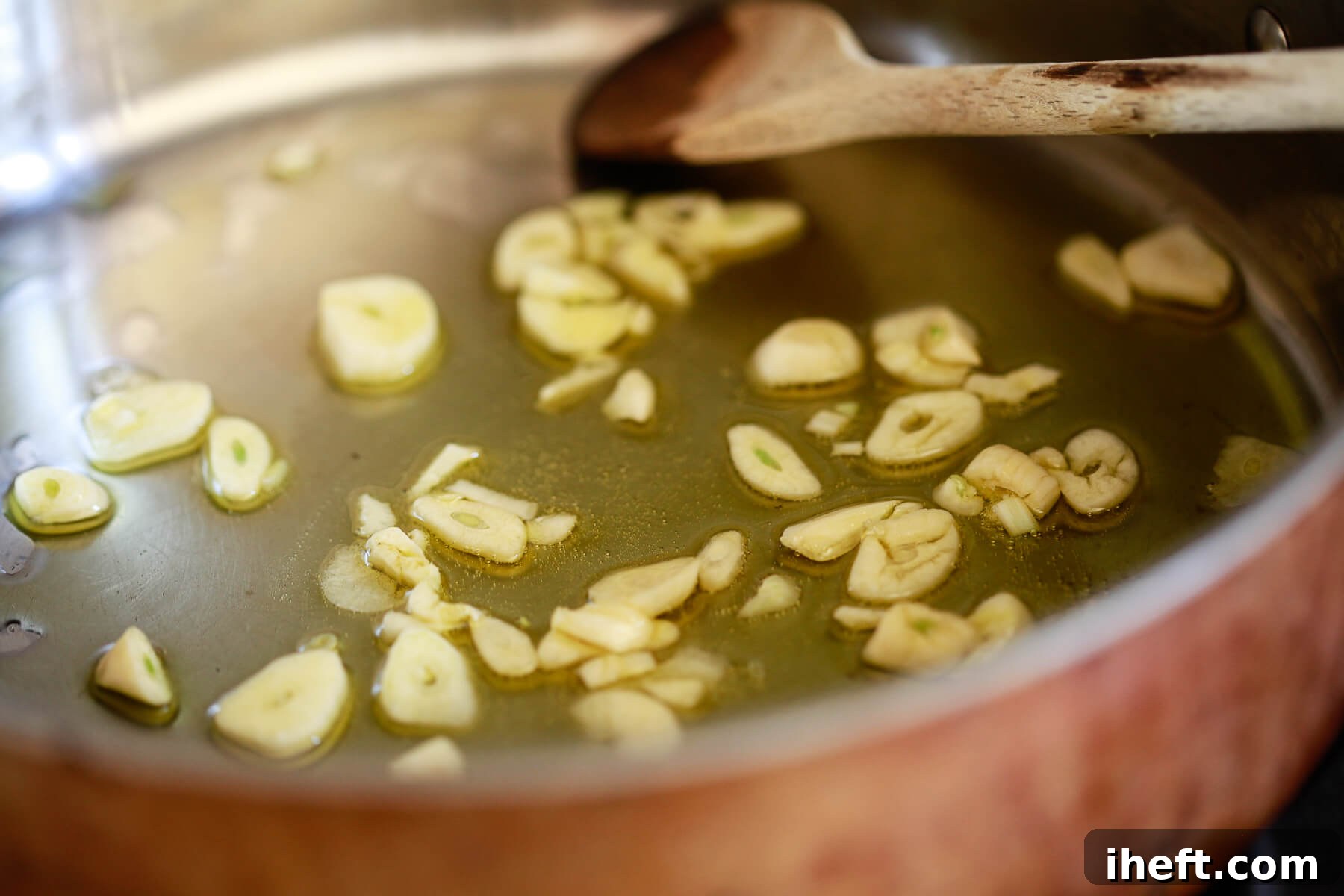 Garlic slices sizzling in olive oil.