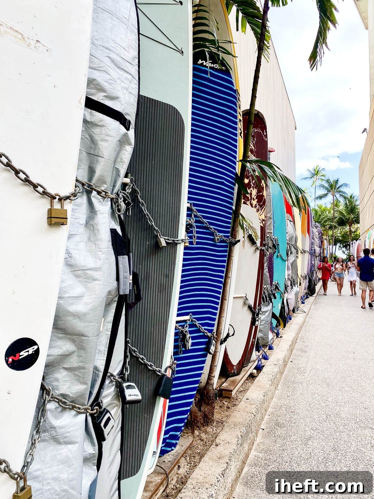Surfboards are lined and locked on a walkway to Waikiki beach. 