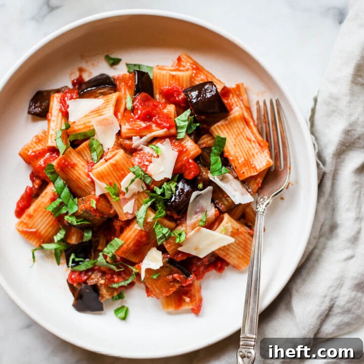 Pasta alla normal eggplant ragu on a white ceramic plate.