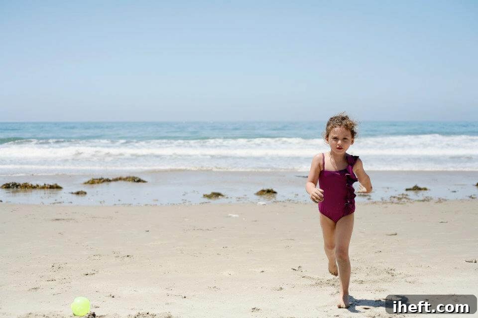 A young girl runs in front of the ocean at a beach in Santa Barbara. 