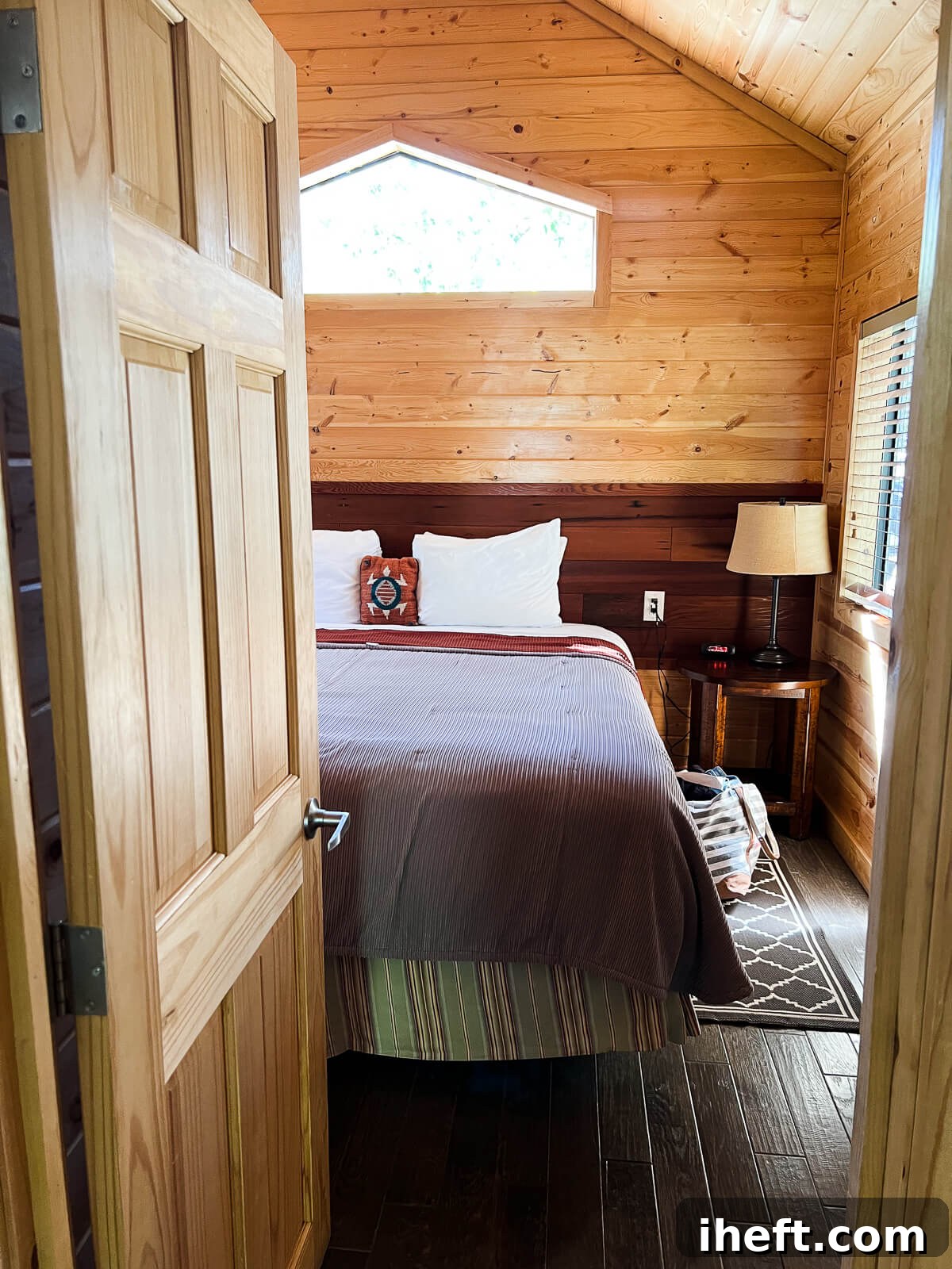 A serene glimpse into the private bedroom of an El Capitan Canyon resort cabin, featuring a comfortable bed and tasteful decor, promising a restful night's sleep amidst nature.