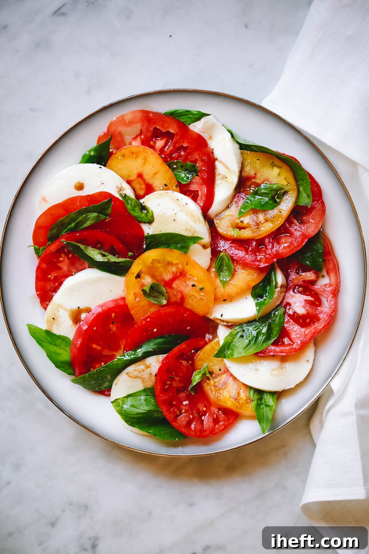A vibrant plate of Caprese salad, showcasing fresh tomatoes, creamy mozzarella, and fragrant basil, a culinary tribute to the Italian flag.