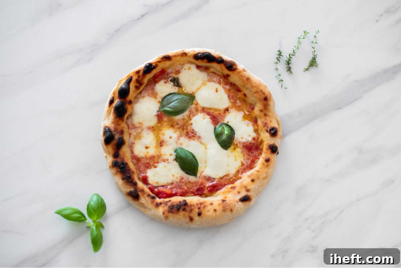 A classic Pizza Margherita adorned with fresh basil leaves, resting on a pristine white marble countertop, embodying traditional Italian simplicity.