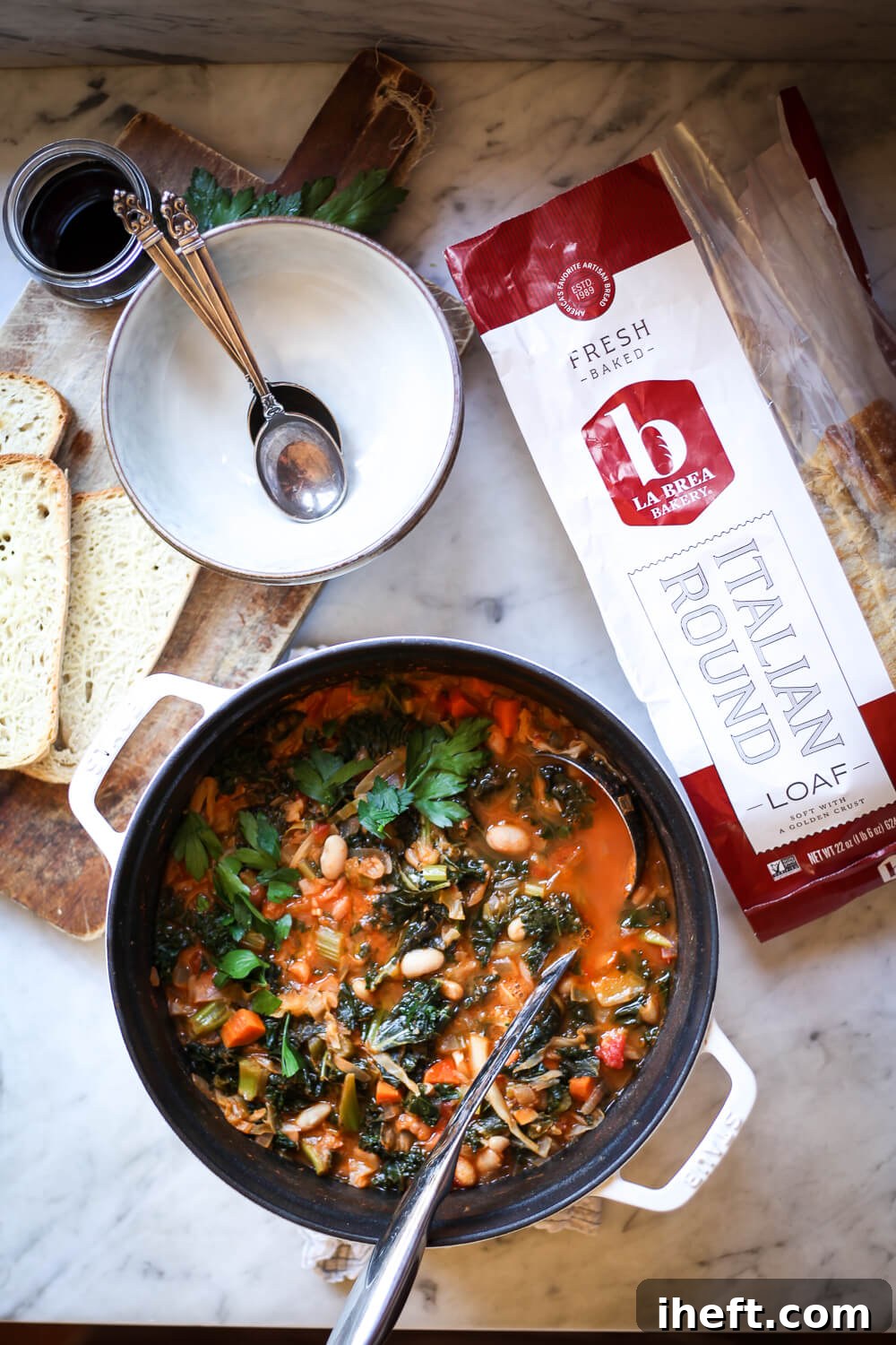 A white pot filled with homemade Ribollita soup, rich with kale and white beans, ready to be served.
