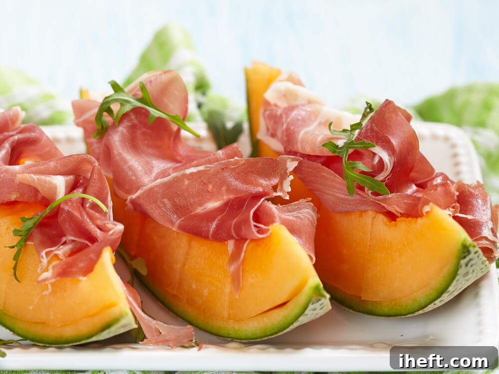 Three elegant wedges of cantaloupe artfully topped with delicate slices of prosciutto and fresh arugula, presenting a traditional Italian antipasto.