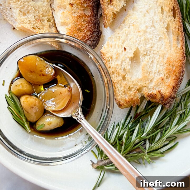 A small dish filled with homemade garlic confit and balsamic on a white plate with bread.