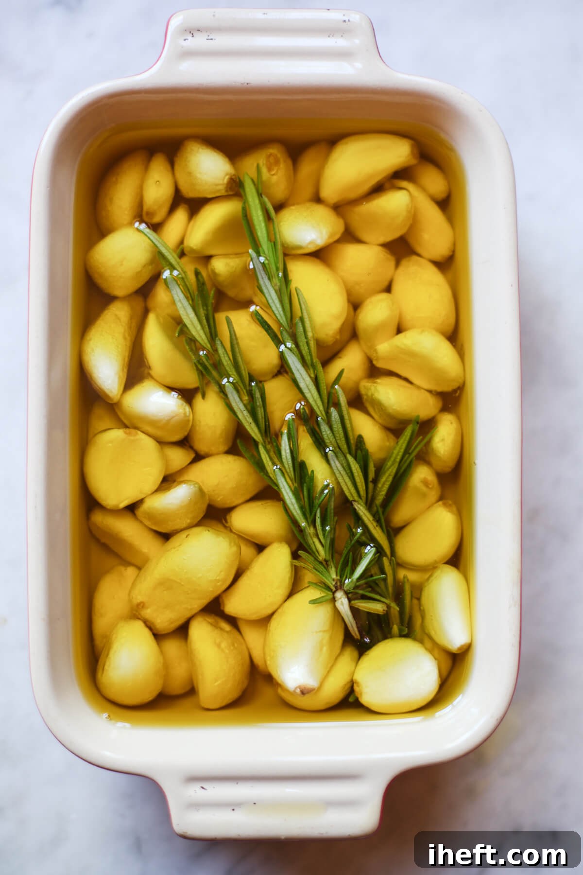 about 50 cloves of garlic covered in oil in a small baking dish.