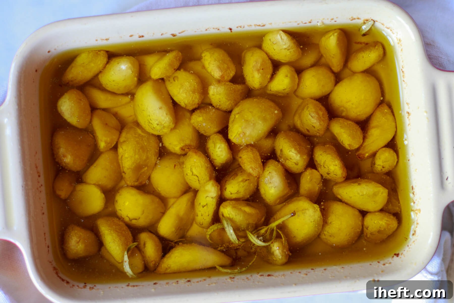Garlic confit right out of the oven in a small rectangular baking dish.