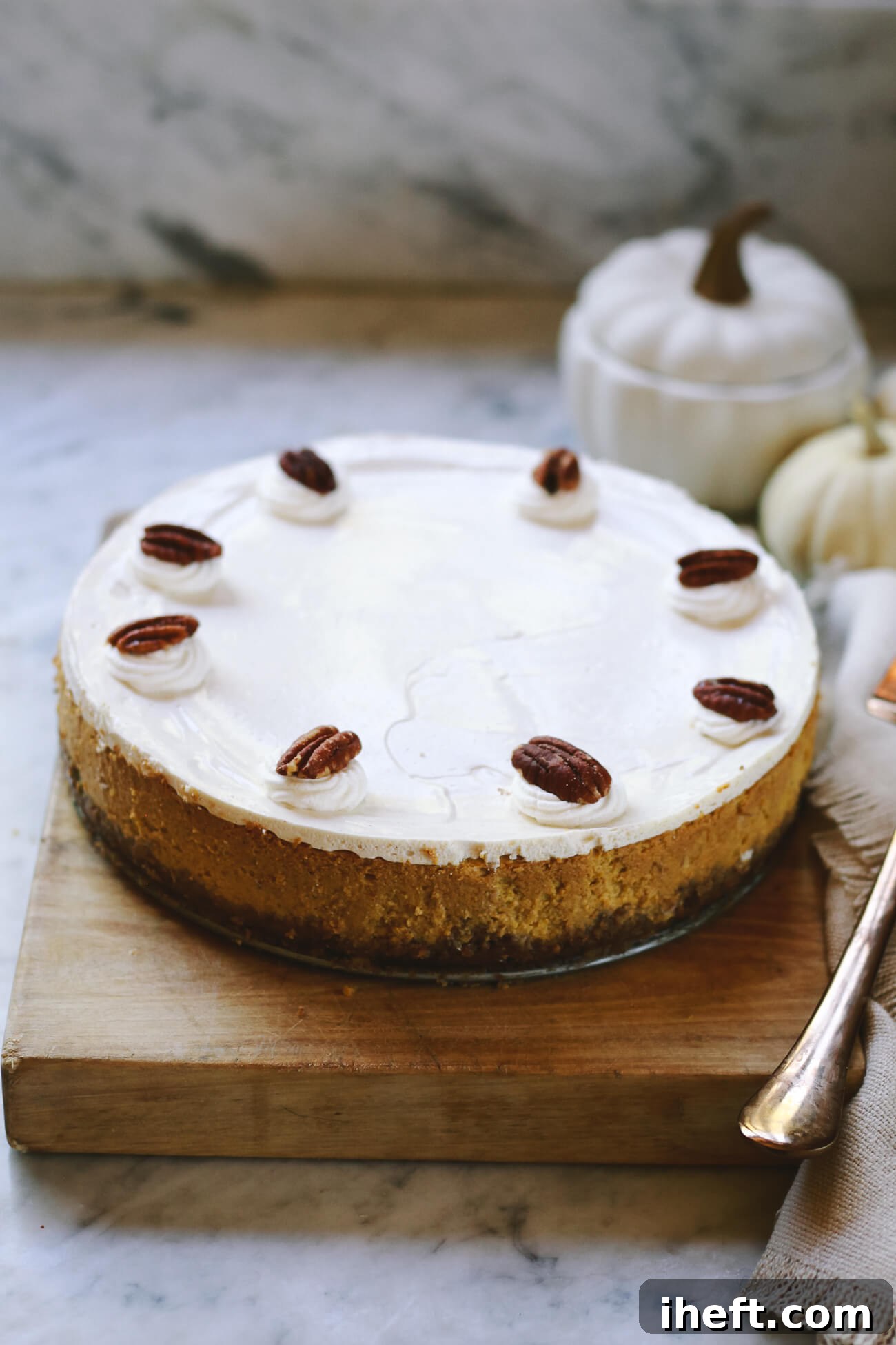 Close-up of a perfectly baked pumpkin cheesecake, showcasing its golden crust and smooth top, ready for the sour cream topping application.